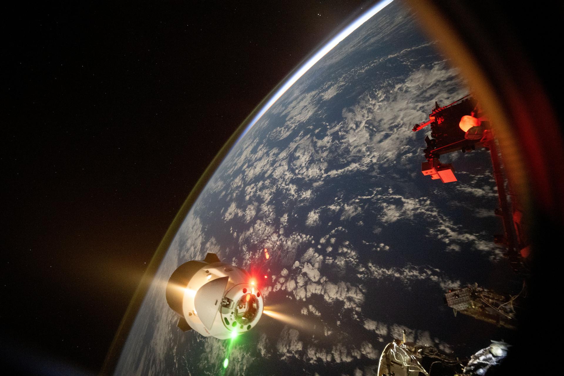 This frame from a time-lapse video captured by NASA astronaut Don Pettit shows the thrusters firing on the SpaceX Dragon cargo spacecraft after it undocked and backed away from the International Space Station's forward port on the Harmony module. The orbital outpost was soaring 259 miles above the Pacific Ocean west of the Hawaiian island chain at the time of this photograph.
