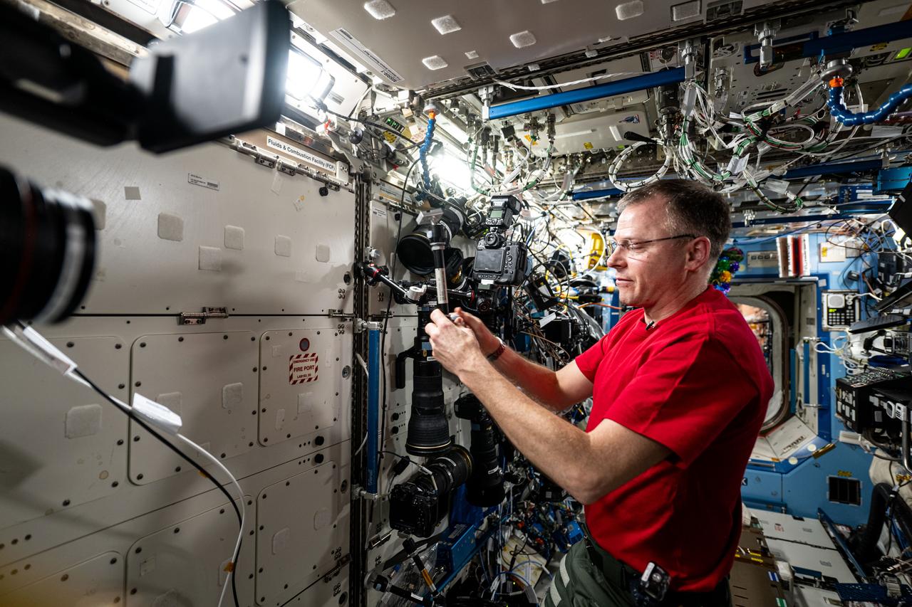 iss072e391307 (Dec. 17, 2024) --- NASA astronaut and Expedition 72 Flight Engineer Nick Hague demonstrates the range of motion and stability of student-designed space hardware aboard the International Space Station's Destiny laboratory module. Hague was testing the HUNCH (High school students United with NASA to Create Hardware) Utility Bracket for its ability to hold and position cameras, computer tablets, and other tools astronauts use daily.