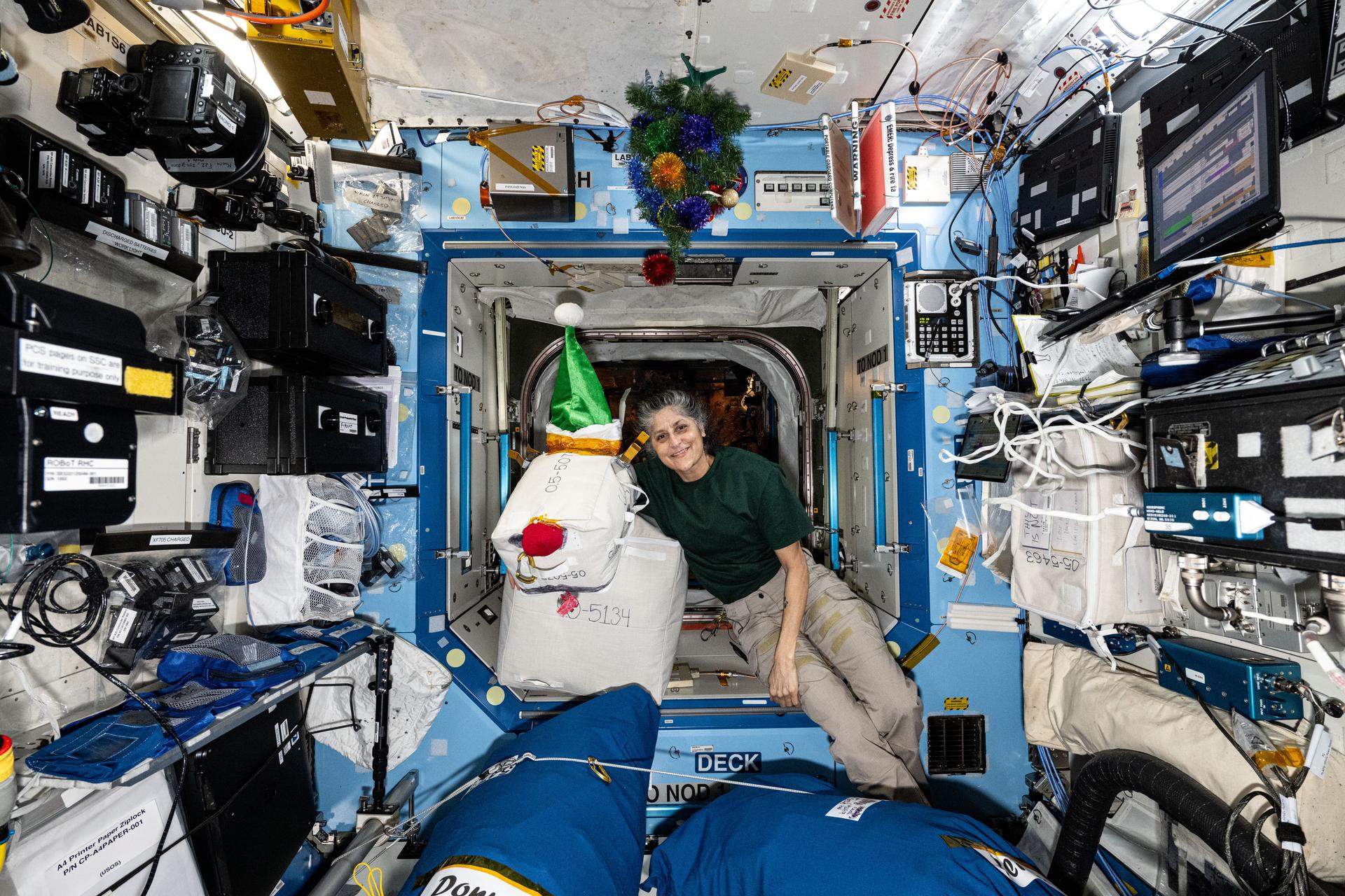 NASA astronaut and Expedition 72 Commander Suni Williams shows off a holiday decoration of a familiar reindeer aboard the International Space Station. The decoration was crafted with excess hardware, cargo bags, and recently-delivered Santa hats.
