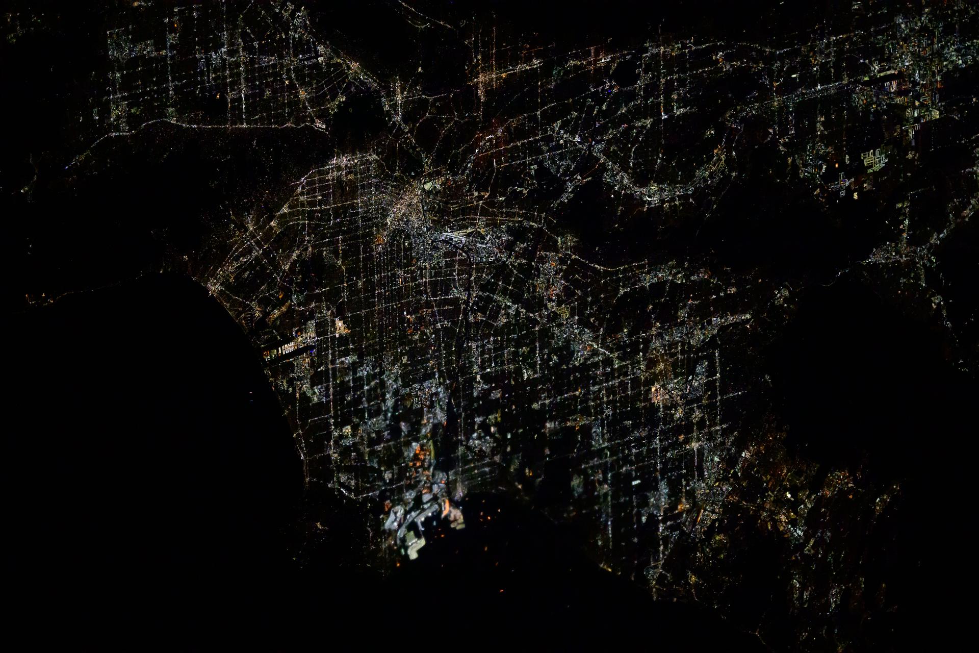 The city lights of Los Angeles, California, and its Terminal Island (center bottom) housing industry, a port, and a correctional facility, are pictured about 4:15 a.m. local time from the International Space Station as it orbited 257 miles above.