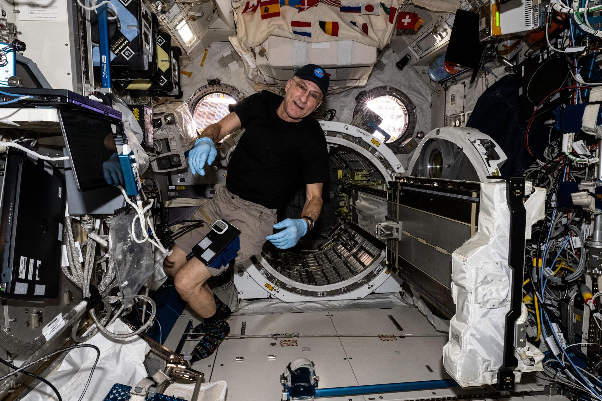NASA astronaut and Expedition 72 Flight Engineer Don Pettit removes the small satellite orbital deployer from the Kibo laboratory module's airlock after several CubeSats were deployed outside the International Space Station into Earth orbit for educational research.