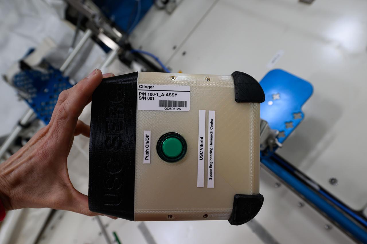 iss072e423784 (1/3/2025) —  A view of the CLINGERS Cubesat aboard the International Space Station  (ISS).  Flight Tech Demo of Docking/Undocking Cubesats Inside ISS (CLINGERS) uses the International Space Station’s Astrobee robots to demonstrate an adaptor for docking and close approach sensing to connect both active and passive objects in space. These are critical functions to enable applications such as satellite servicing, orbital refueling, spacecraft repair and upgrade, and in-orbit manufacturing.