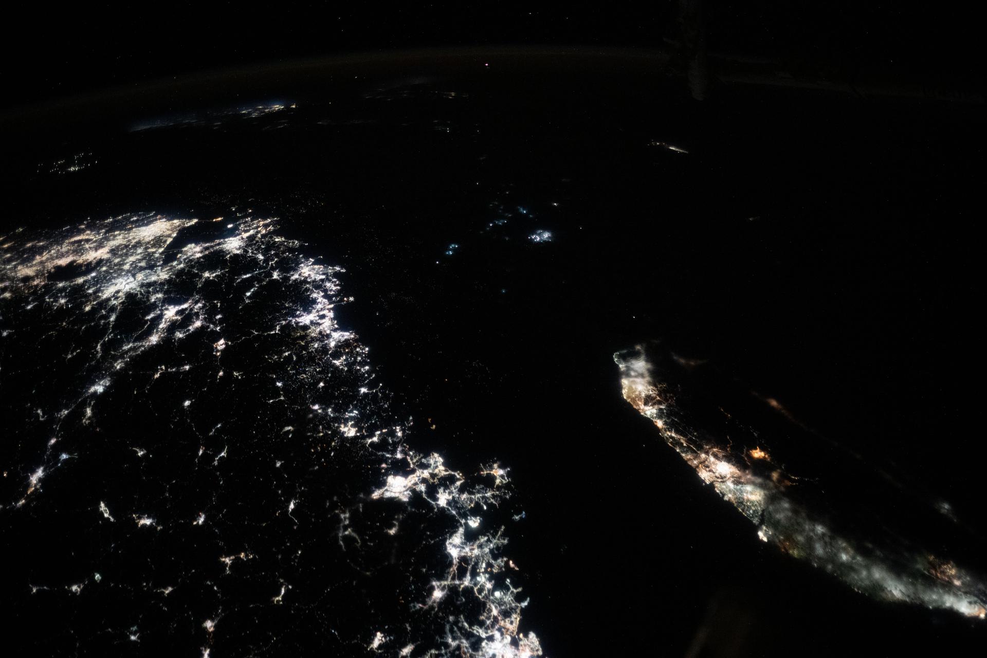 The Taiwan Strait separates China's southeast coast from Taiwan in this photograph from the International Space Station as it orbited 257 miles above Asia. From bottom center toward the upper left, the city lights from Quanzhuo to Shanghai light up the Chinese coast. Toward right center, the city lights from Taipei to Tainan (bottom right) illuminate Taiwan's western coast. This frame was captured approximately 12:51 a.m. local time.