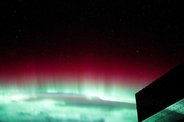 NASA image: A red and green aurora borealis above Canada's Gulf of St. Lawrence