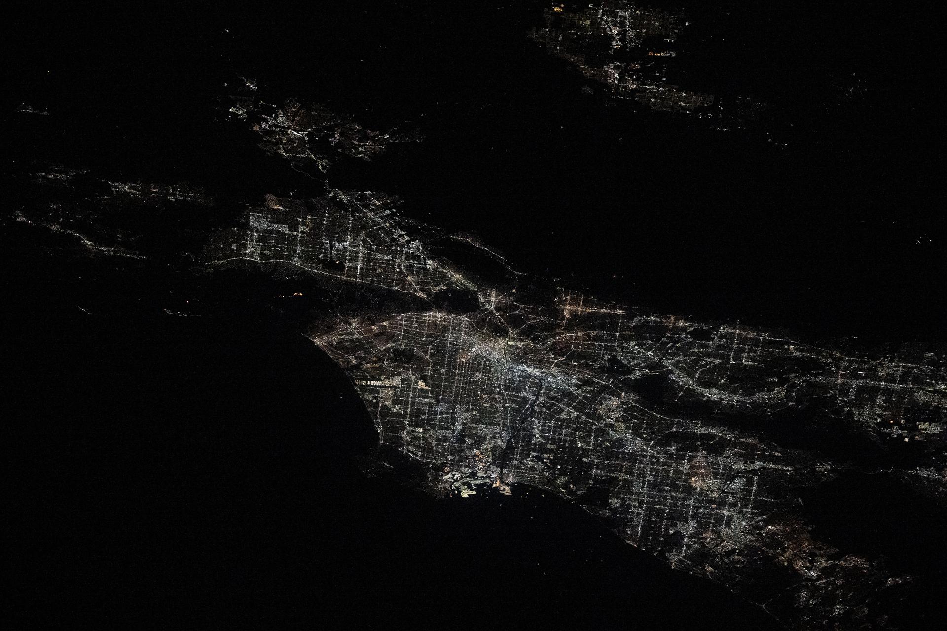 City lights illuminate the Los Angeles, California, metropolitan area at approximately 2:30 a.m. local time as the Palisades, Hurst, and Eaton wildfires rage around nearby suburbs including Malibu, San Fernando, and Pasadena. The International Space Station was orbiting 258 miles above the southwestern United States at the time of this photograph. Credit: NASA/Don Pettit