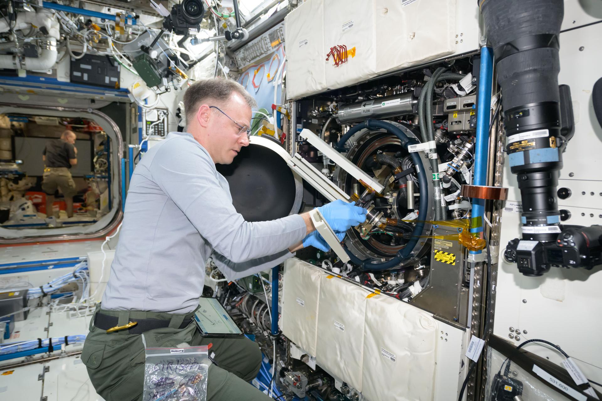 NASA astronaut and Expedition 72 Flight Engineer Nick Hague works in the Destiny laboratory module's Combustion Integrated Rack swapping samples of materials to observe how they burn in weightlessness. The investigation taking place inside the International Space Station's CIR enables the safe observation of flames and how they spread in microgravity potentially improving fire safety on crew missions.