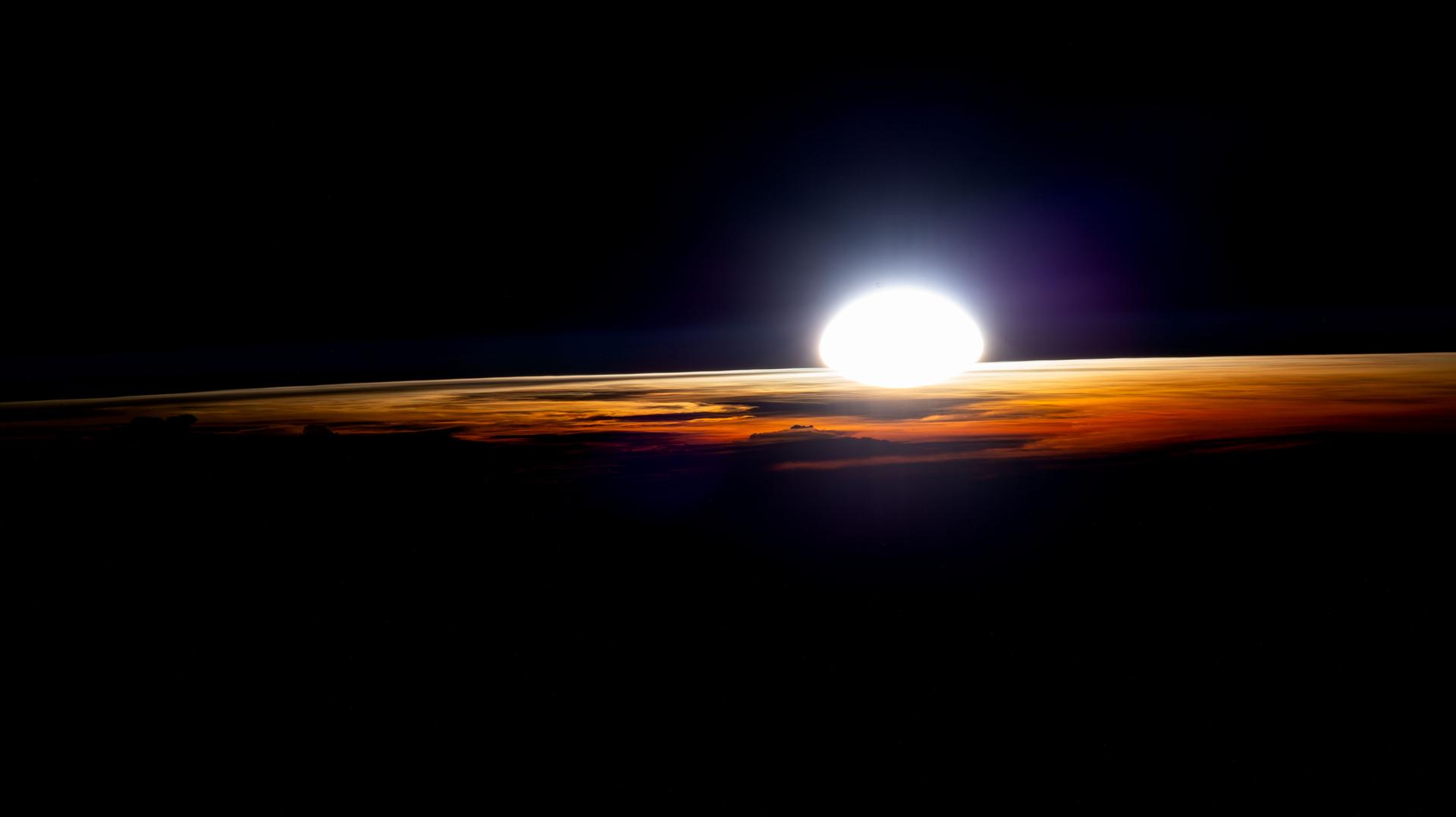 An orbital sunrise illuminates the cloud tops in this photograph from the International Space Station as it soared 262 miles above Namibia near the Atlantic coast.