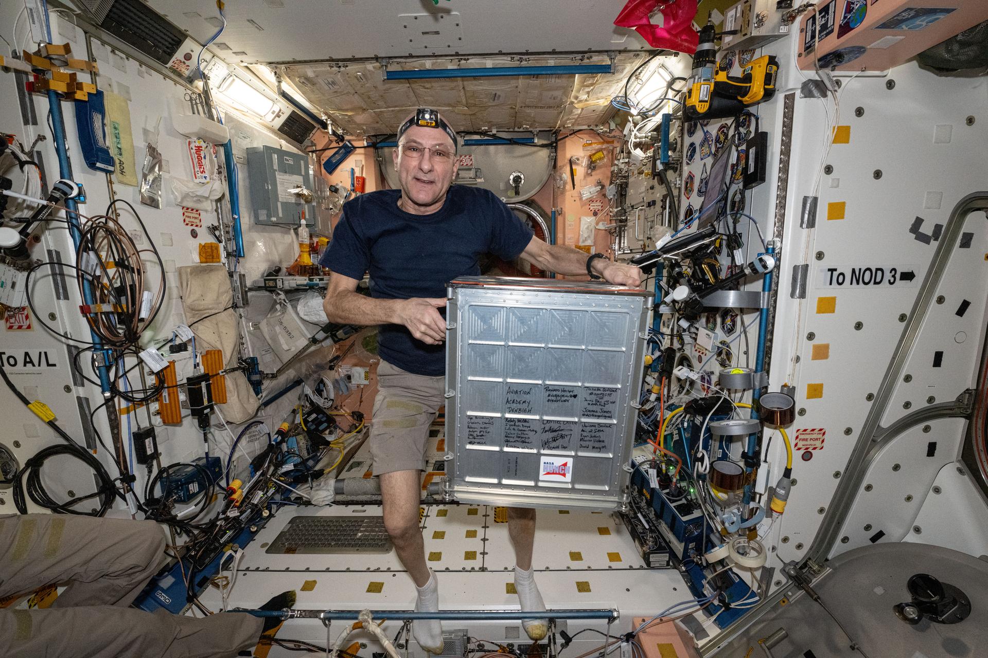 NASA astronaut and Expedition 72 Flight Engineer Don Pettit displays HUNCH (High school students United with NASA to Create Hardware) gear inside the International Space Station's Unity module. The HUNCH mission empowers and inspires high school students to learn 21st-century skills and particpate in the design and fabrication of real-world tools for NASA.