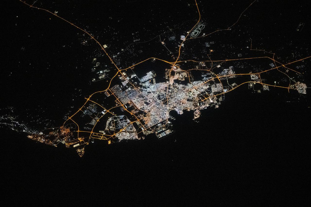 iss072e519924 (Jan. 23, 2025) --- The city lights of Doha, Qatar, the Middle Eastern nation's capital with a population of about 1.2 million, are pictured at approximately 9:51 p.m. local time from the International Space Station as it orbited 258 miles above. Some prominent landmarks include the Shahaniyah Camel Race Track (top right), Hamad International Airport, and the artificial Pearl Island (both at center and on the Persian Gulf Coast).