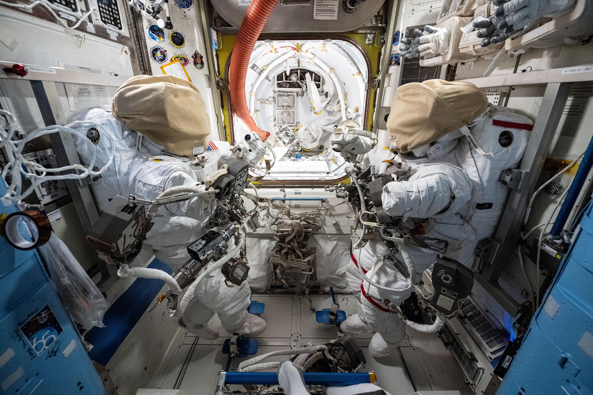 Two spacesuits are staged inside the International Space Station's Quest airlock