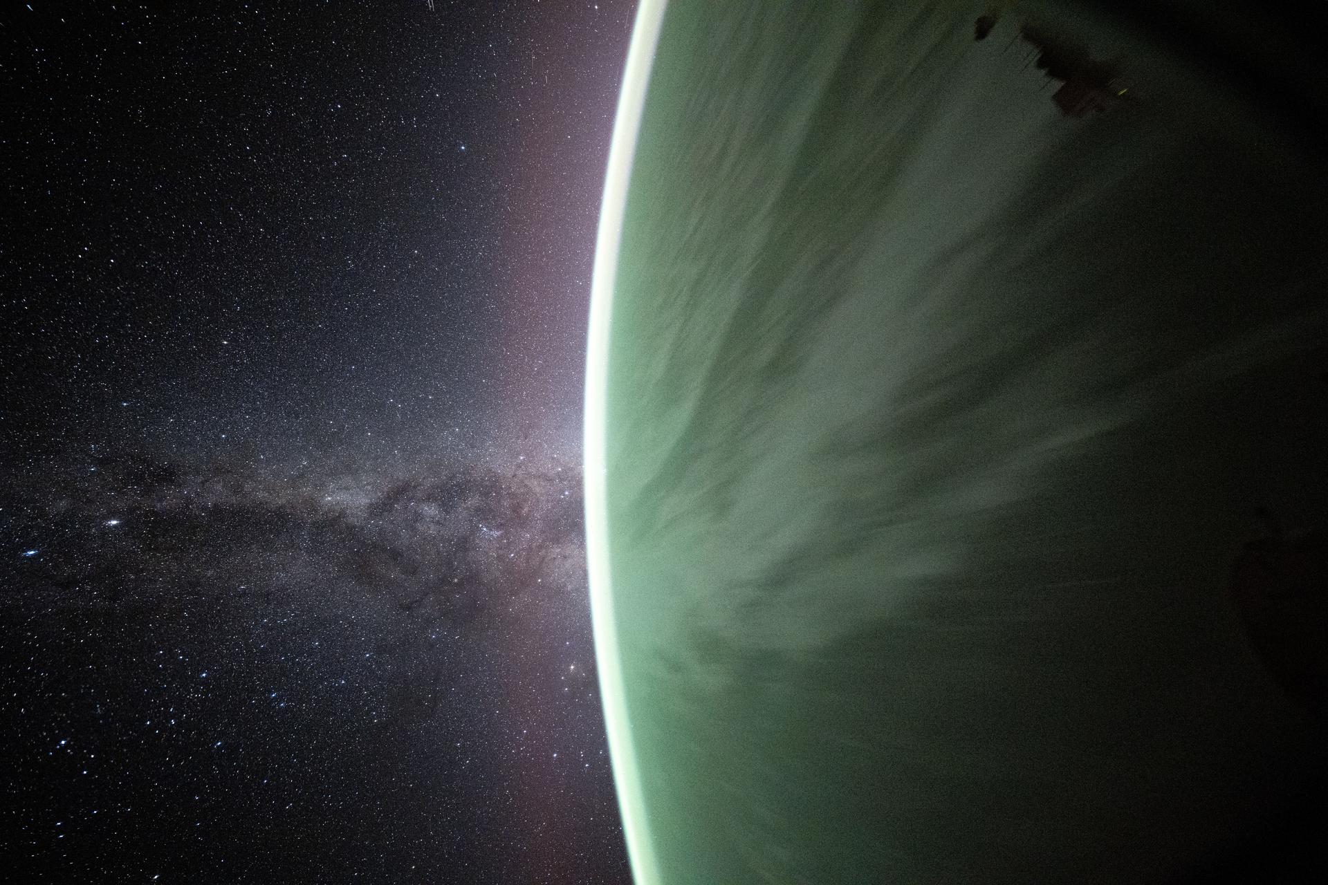 The Milky Way appears beyond Earth's horizon in this celestial photograph captured by NASA astronaut Don Pettit using a camera with low light and long duration settings pointed out a window on the SpaceX Dragon crew spacecraft. The International Space Station was orbiting 263 miles above the Pacific Ocean just before sunrise.