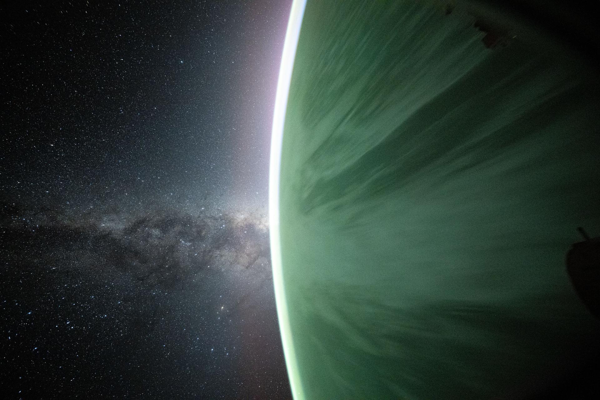 The Milky Way appears beyond Earth's horizon in this celestial photograph captured by NASA astronaut Don Pettit using a camera with low light and long duration settings pointed out a window on the SpaceX Dragon crew spacecraft. The International Space Station was orbiting 265 miles above the Pacific Ocean off the coast of Chile just before sunrise.
