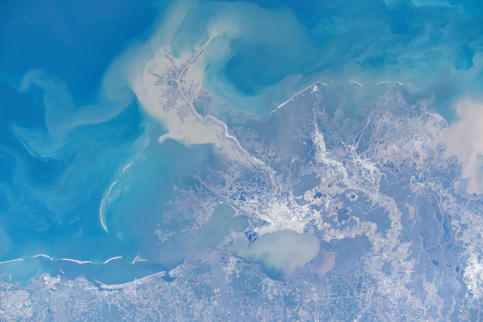New Orleans, Louisiana, and its suburbs along the Mississippi River and on the shoreline of Lake Pontchartrain are pictured from the International Space Station as it orbited above.