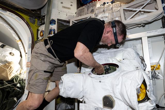 NASA image: Astronaut Butch Wilmore replaces components on a spacesuit