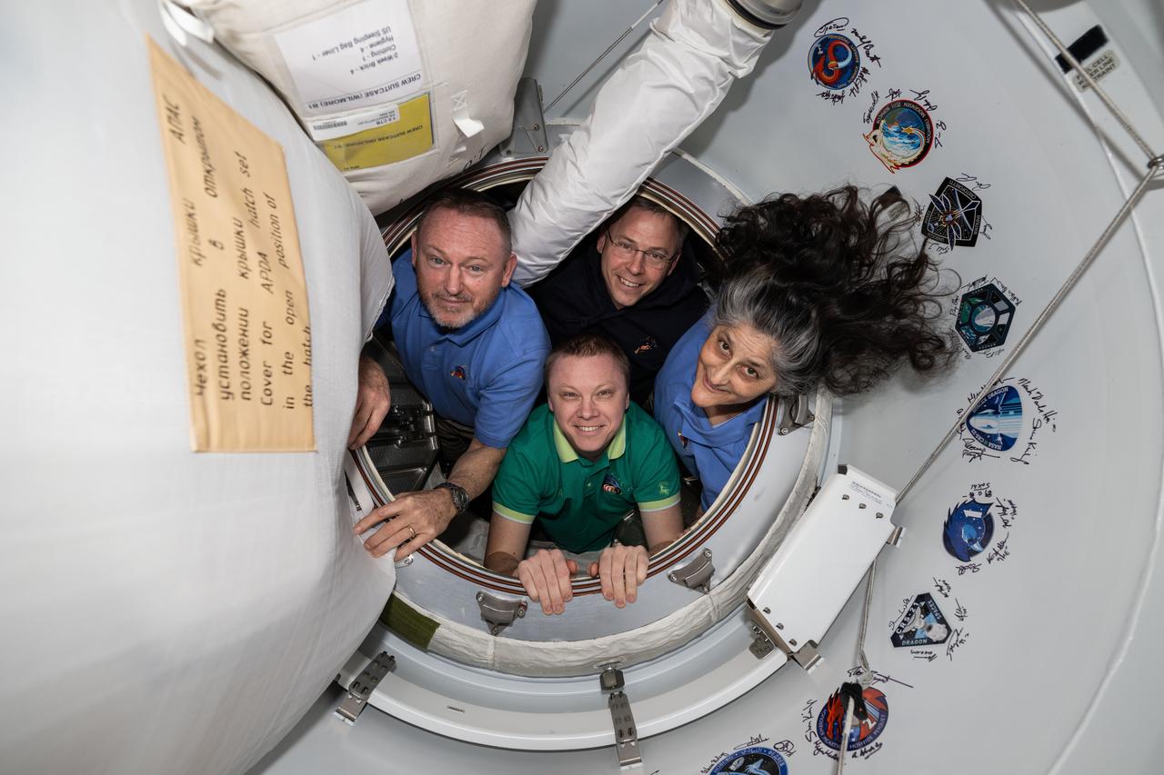 iss072e645464 (Feb. 19, 2025) --- NASA's SpaceX Crew-9 members pose together for portrait inside the vestibule between the International Space Station and the SpaceX Dragon crew spacecraft. Clockwise from left, are NASA astronauts Butch Wimore, Nick Hague, and Suni Williams, and Roscosmos cosmonaut Aleksandr Gorbunov.