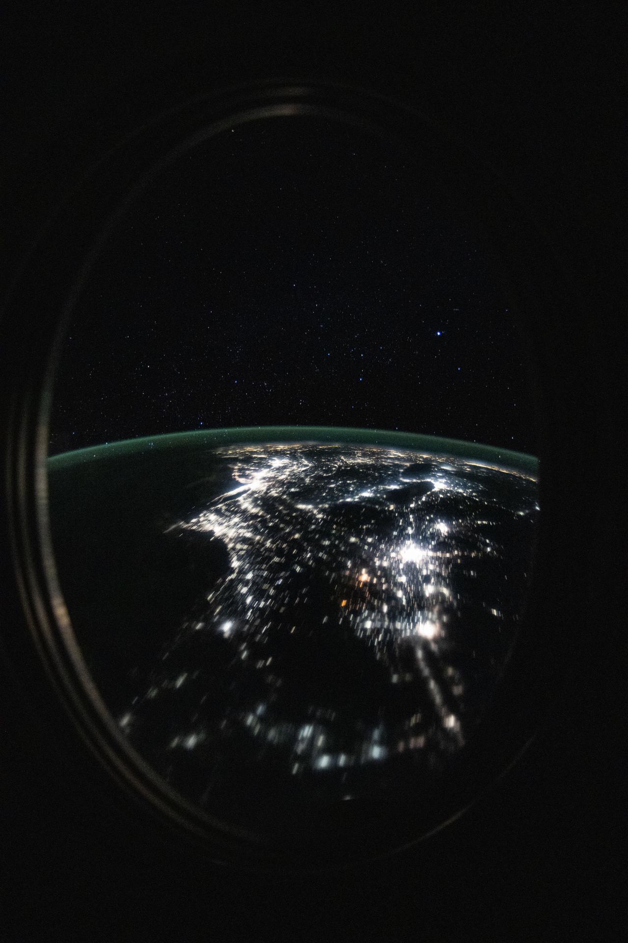 This long-duration photograph looks out a window on the SpaceX Dragon crew spacecraft and down the eastern coast of the United States at approximately 12:34 a.m. local time as the International Space Station orbited 264 miles above Newfoundland, Canada.
