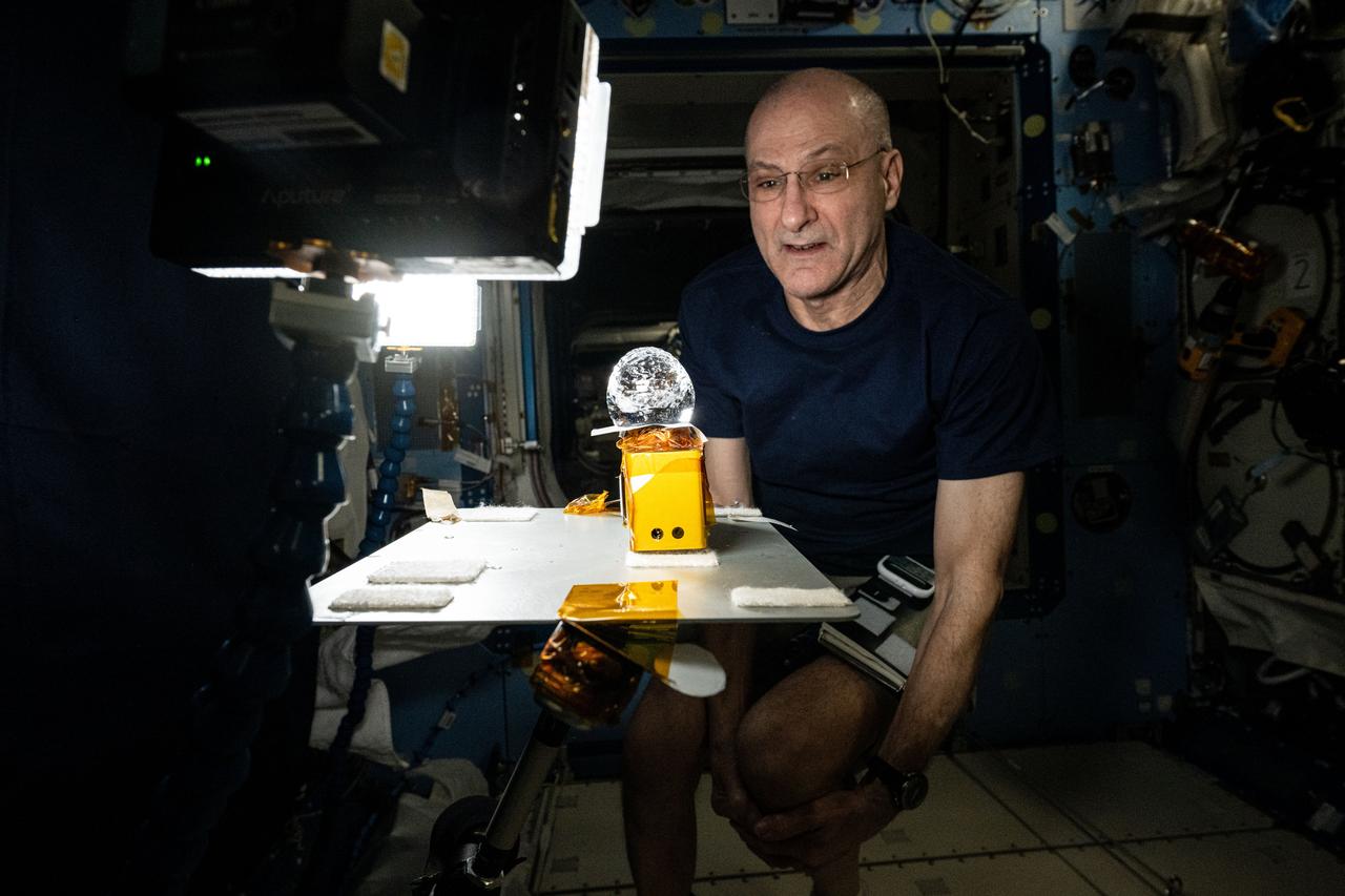 iss072e742508 (March 2, 2025) --- NASA astronaut and Expedition 72 Flight Engineer Don Pettit stares at a ball of water shaped by microgravity and attached to research hardware by surface tension. Pettit was demonstrating simple space physics phenomena inside the International Space Station's Kibo laboratory module.