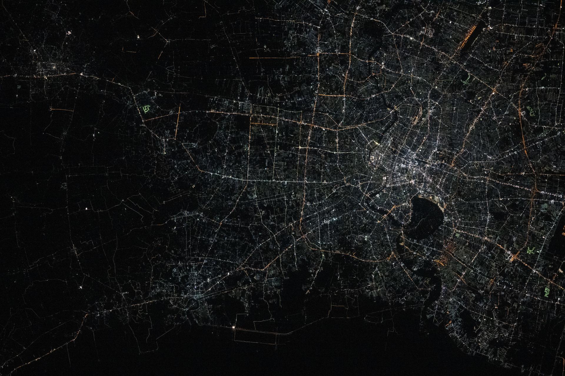 iss072e757257 (March 5, 2025) --- Bangkok, Thailand—with a metropolitan population of about 11.4 million and split by the Chao Phraya river—is pictured from the International Space Station at approximately 1:48 a.m. local time as it orbited 257 miles above the Southeast Asian nation. The dark area toward the center-right is part of the Phra Pradaeng District, a lush, green peninsula known as Bang Krachao. Preserved as an urban green space, it helps mitigate Bangkok’s pollution and urban density.