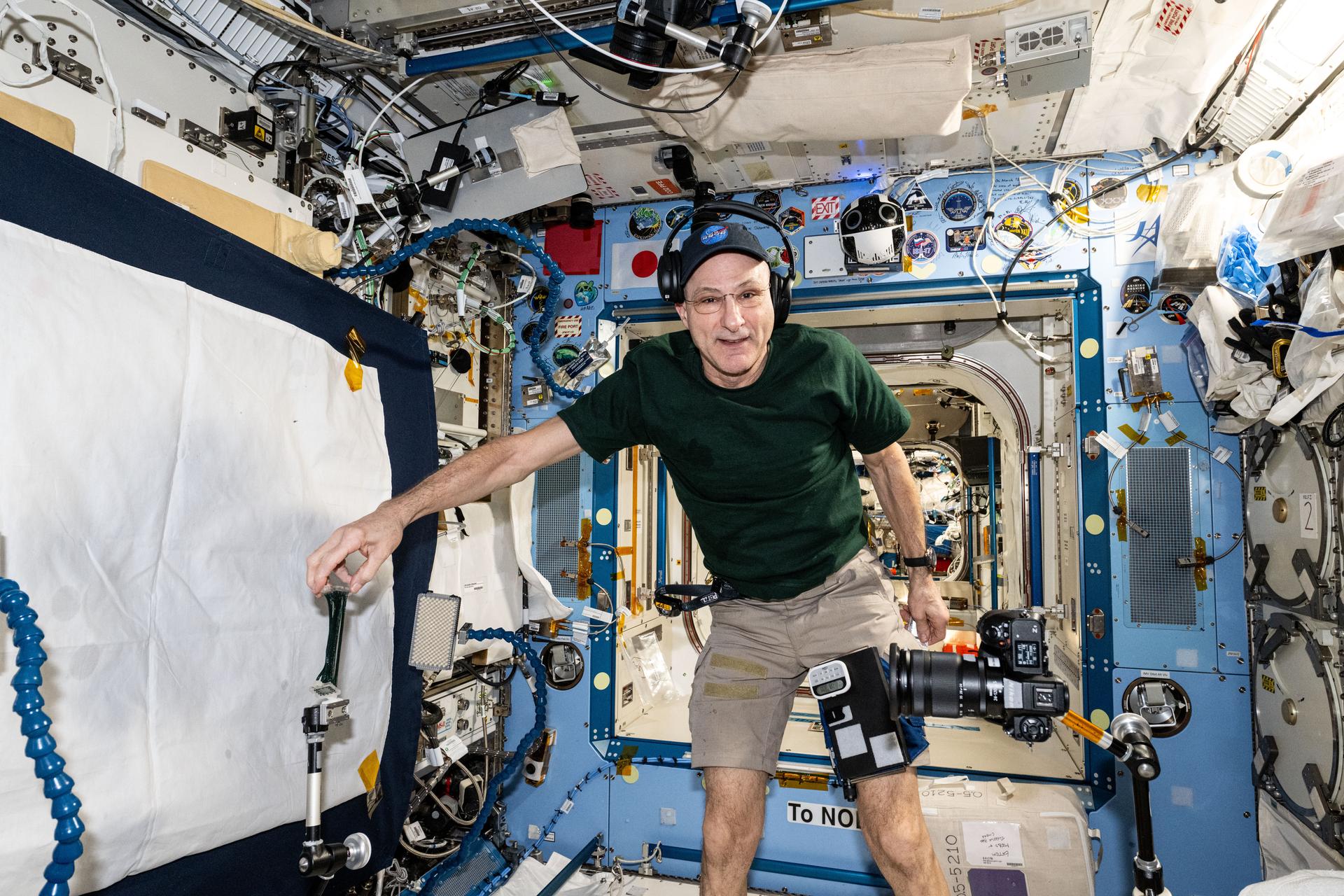 NASA astronaut and Expedition 72 Flight Engineer Don Pettit sets up camera hardware to photograph research activities inside the International Space Station's Kibo laboratory module.