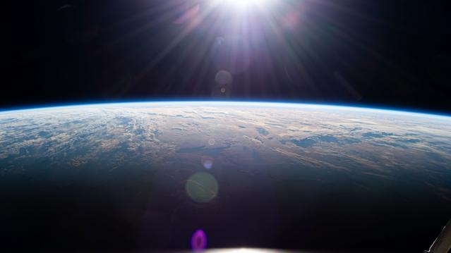 NASA image: Sunrise above Earth's horizon begins illuminating a cloudy Indian Ocean