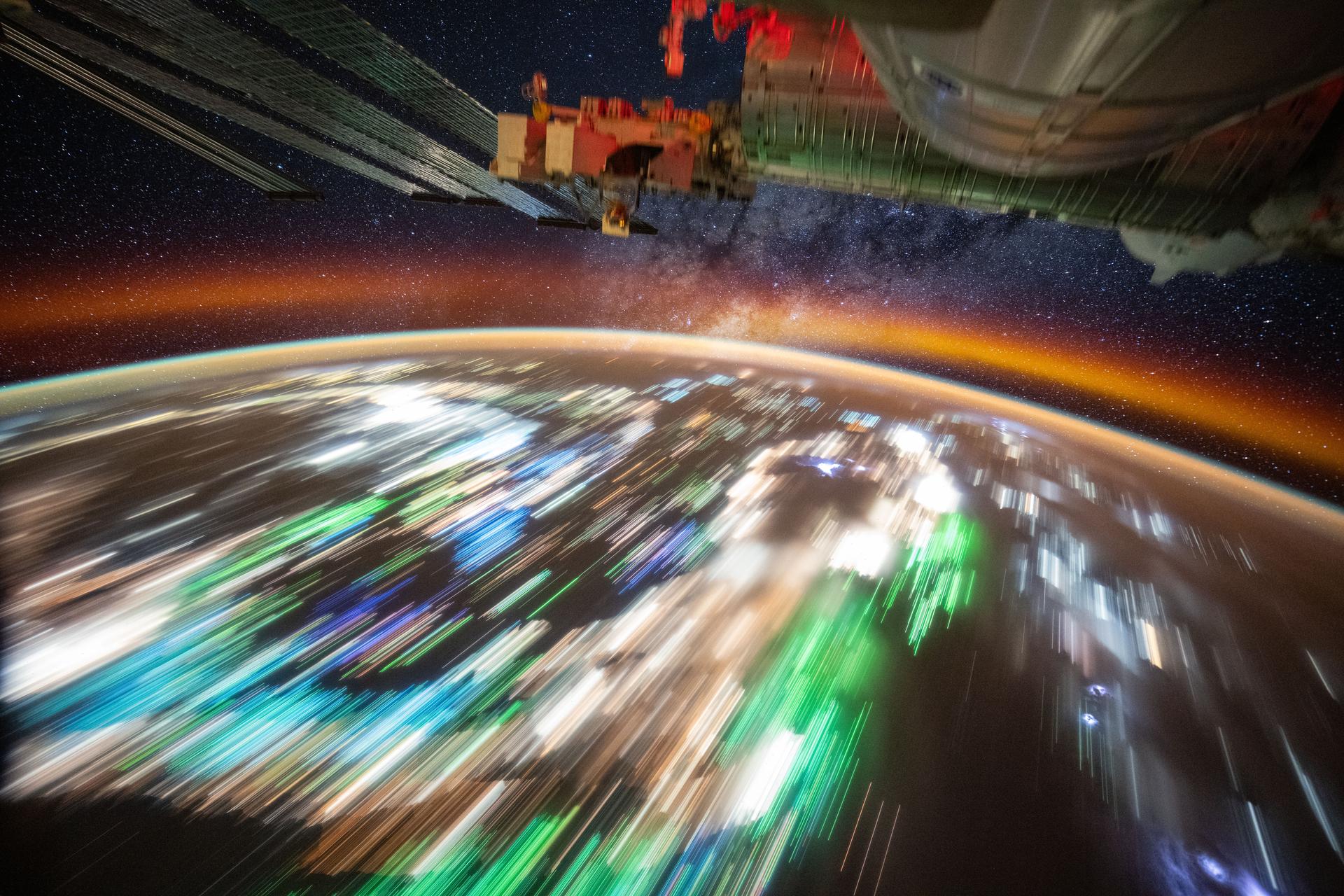 This long-duration photograph taken from the International Space Station as it orbited 259 miles above the Andaman Sea reveals the city lights of Southeast Asia and the typical green lights of the fishing boats underneath Earth's atmospheric glow. In the background, a star-filled sky and the Milky Way sparkle above the planet. Credit: NASA/Don Pettit