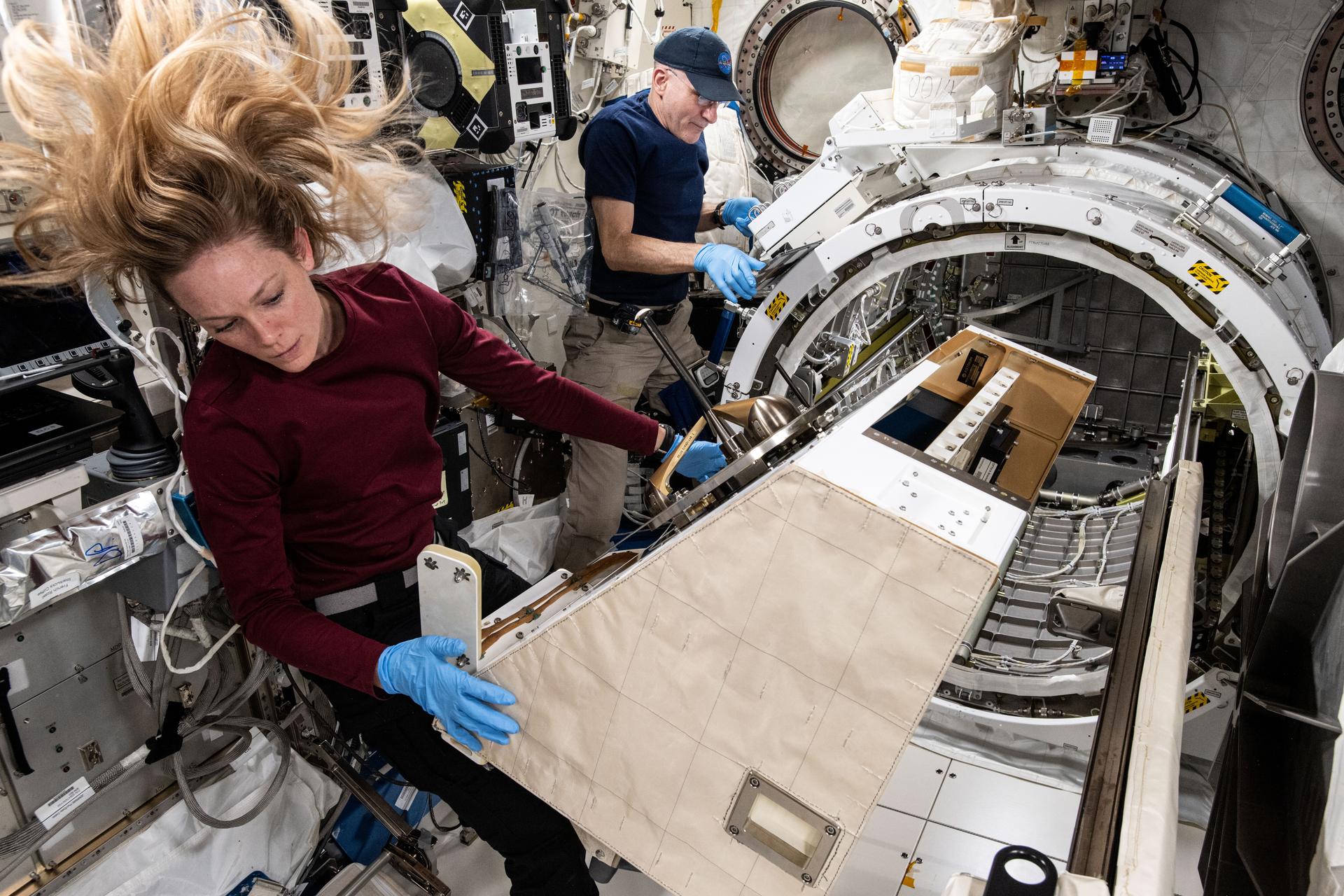 NASA astronauts Nichole Ayers and Don Pettit, both Expedition 72 Flight Engineers, extract the NanoRacks External Platform from the Kibo laboratory module's airlock aboard the International Space Station. The commercial research platform housed three different electrical and optical experiments that tested operations while exposed to the vacuum of space.