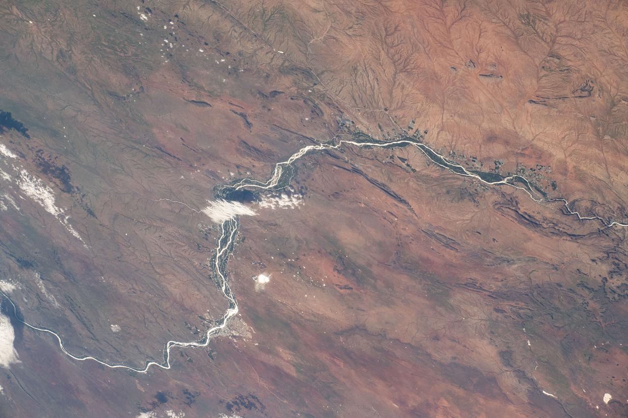 iss072e862232 (March 28, 2025) --- This portion of the Orange River, South Africa's longest river, east of Namibia's southern border and beaming under the sun's glint is pictured from the International Space Station as it orbited 264 miles above.