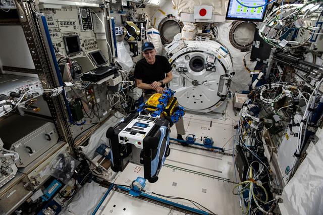 NASA image: Astronaut Don Pettit watches an Astrobee robotic free-flyer grapple a "capture cube"