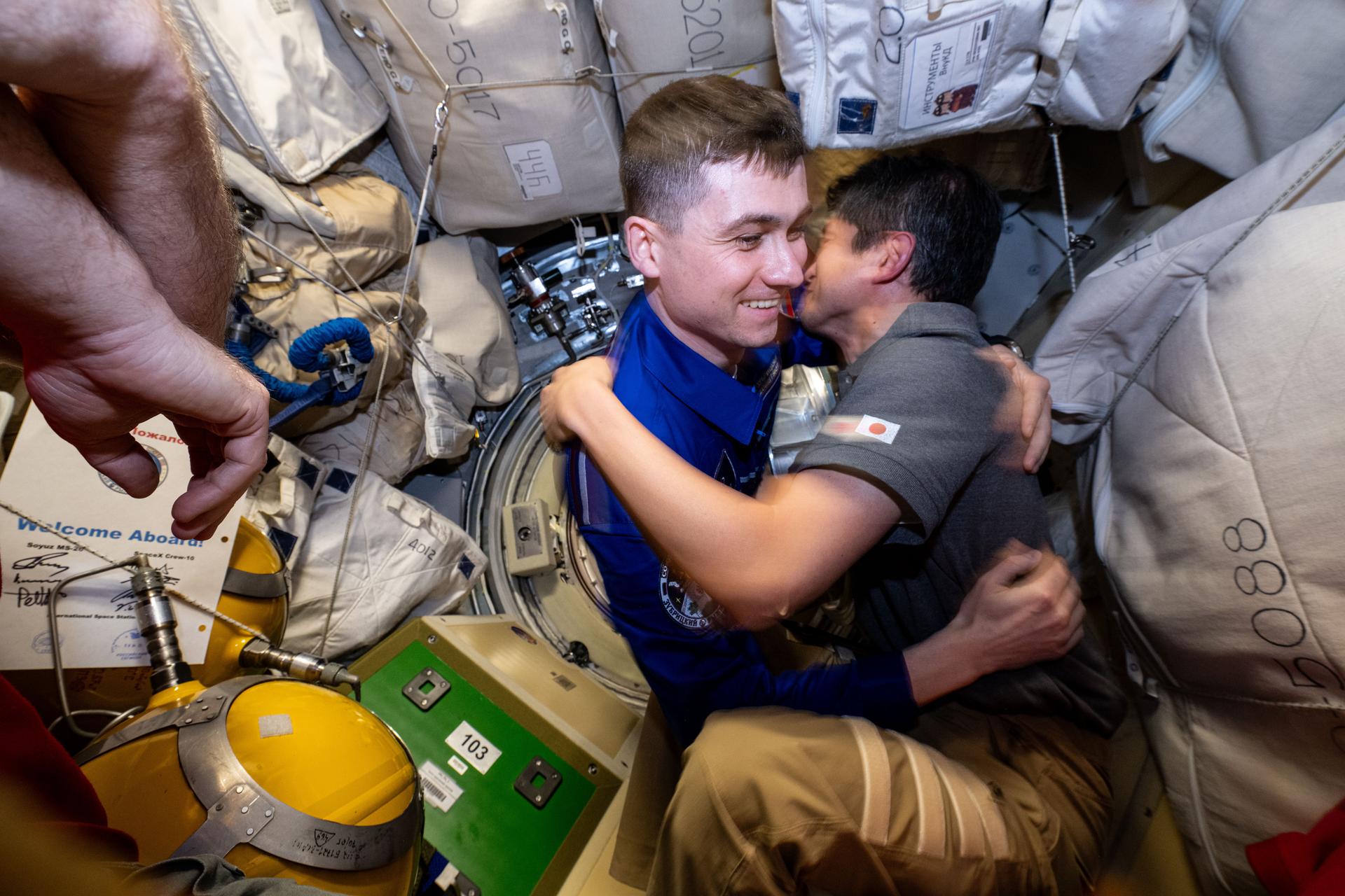 Roscosmos cosmonaut and Expedition 72 Flight Engineer Alexey Zubritsky enters the International Space Station shortly after docking to the Prichal module aboard the Soyuz MS-27 spacecraft. Flight Engineer Takuya Onishi of JAXA (Japan Aerospace Exploration Agency), at right, greets Zubritsky with a hug.