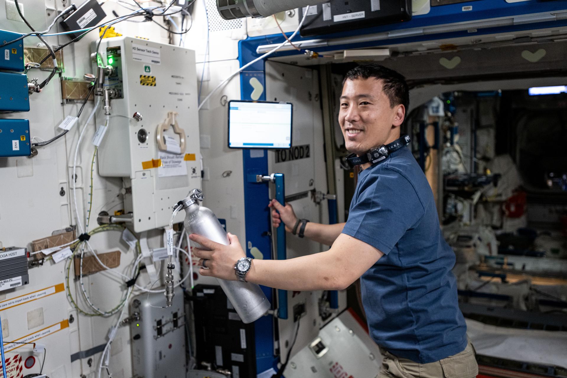 NASA astronaut and Expedition 72 Flight Engineer Jonny Kim installs experimental hydrogen sensors to test the advanced life support gear for longer calibration life and improved reliability aboard the International Space Station's Destiny laboratory module.