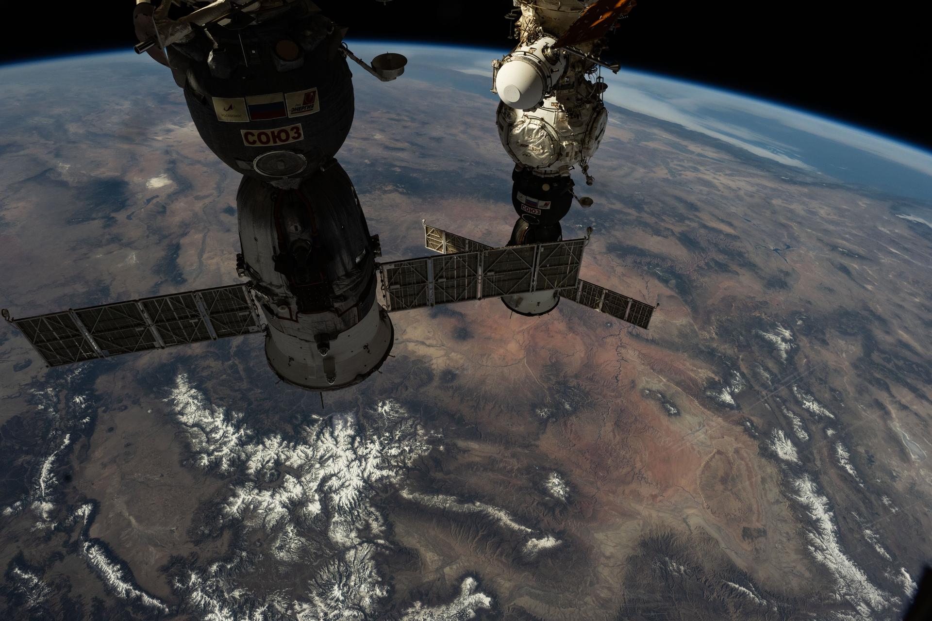 The Soyuz MS-26 (foreground) and MS-27 crew ships are pictured docked to the International Space Station's Rassvet module and Prichal module, respectively. The orbital outpost was soaring 261 miles above Wyoming at the time of this photograph.