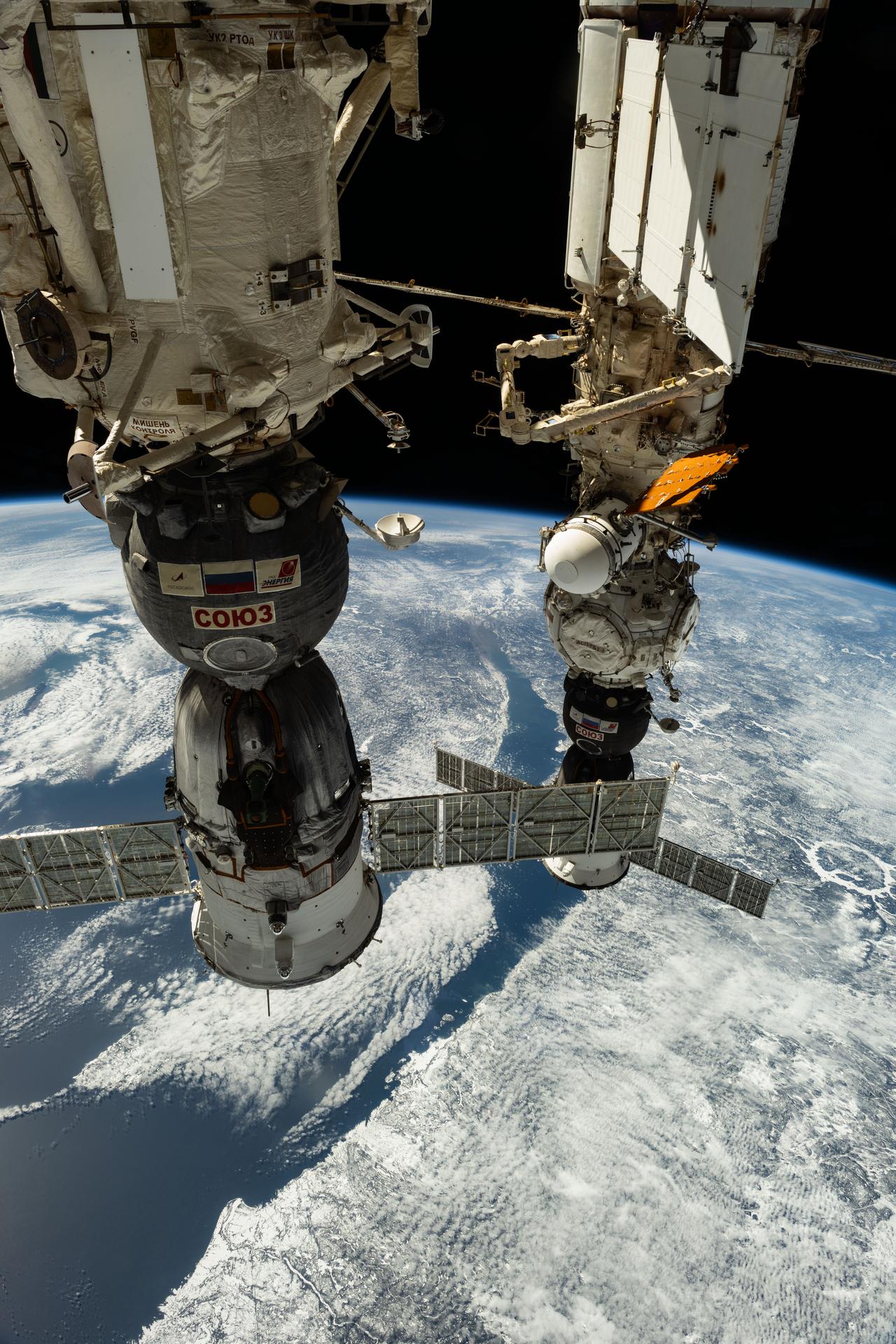 The Soyuz MS-26 (foreground) and MS-27 crew ships are pictured docked to the International Space Station's Rassvet module and Prichal module, respectively. At right, is the 214 million-year-old Manicouagan crater located in Quebec as the orbital outpost soared 263 miles above far eastern Canada.