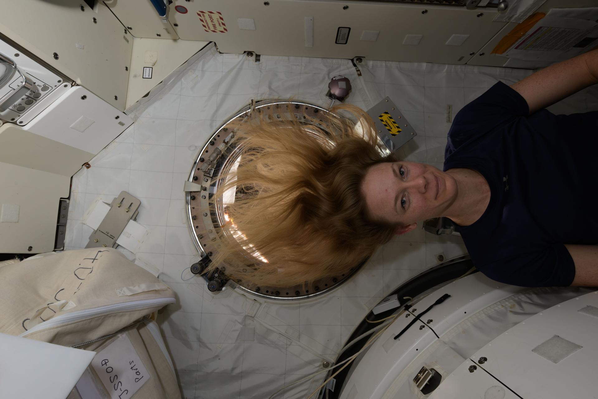 NASA astronaut and Expedition 72 Flight Engineer Nichole Ayers poses for a portrait in front of a window inside the International Space Station's Kibo laboratory module.