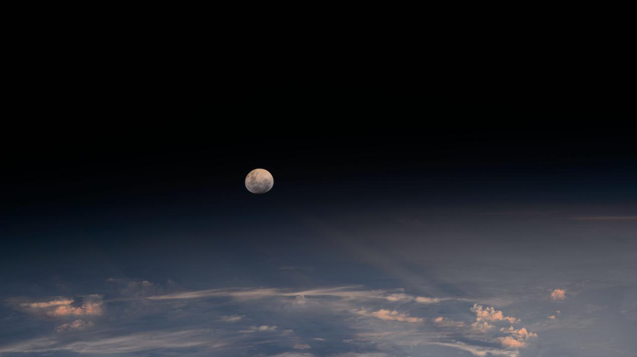 iss072e978997 (April 13, 2025) --- The Moon's light is refracted by the Earth's atmosphere giving it a spheroid shape in this photograph from the International Space Station as it orbited into a sunset 264 miles above the border between Bolivia and Brazil in South America.
