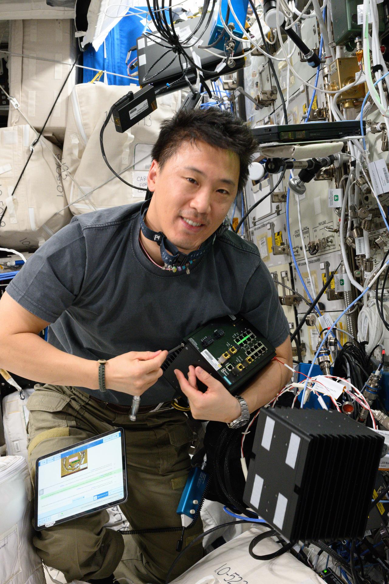 NASA astronaut and Expedition 73 Flight Engineer Jonny Kim works on computer networking maintenance inside the International Space Station's Columbus laboratory module.