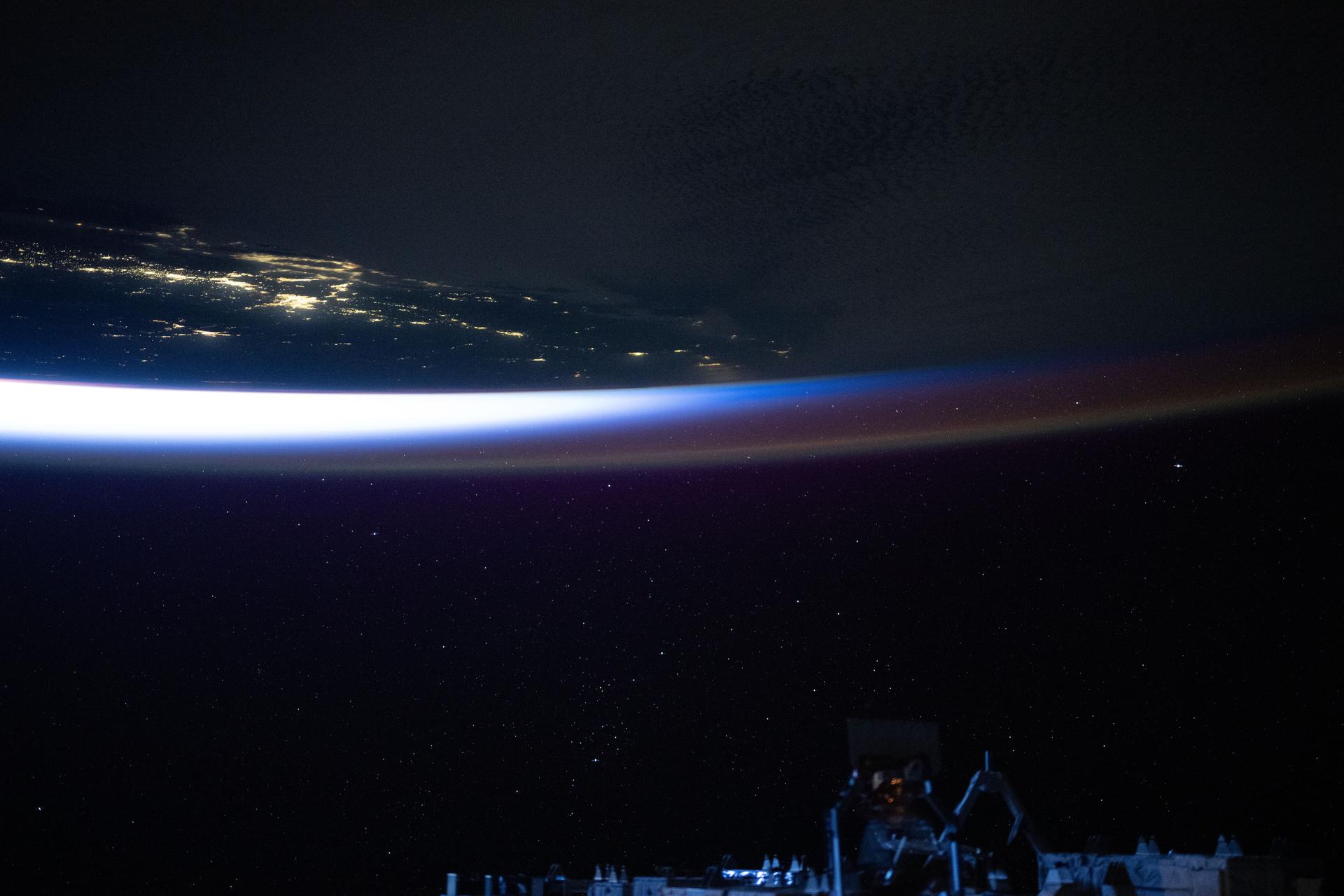 An orbital twilight reveals Earth's horizon and contrasts with the well-lit coast of southern California in this photograph from the International Space Station as it orbited 258 miles above the Pacific Ocean at approximately 4:46 a.m. local time.