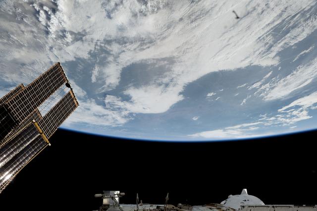 NASA image: The space station orbits above a cloudy North America