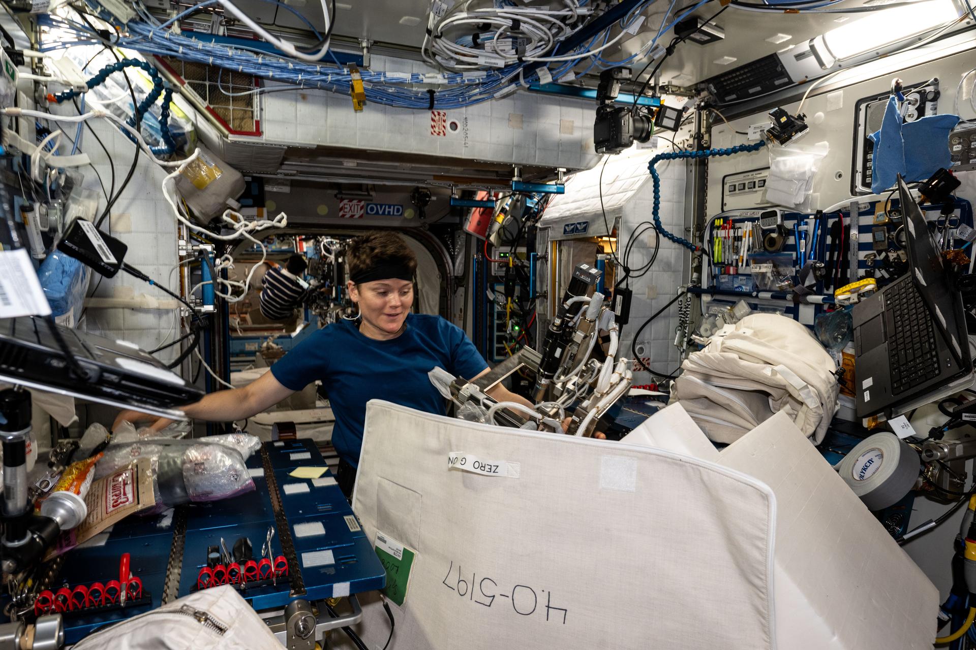 NASA astronaut and Expedition 73 Flight Engineer Anne McClain works inside the International Space Station's Harmony module gathering and organizing cargo to be packed inside the SpaceX Dragon cargo spacecraft before its departure.