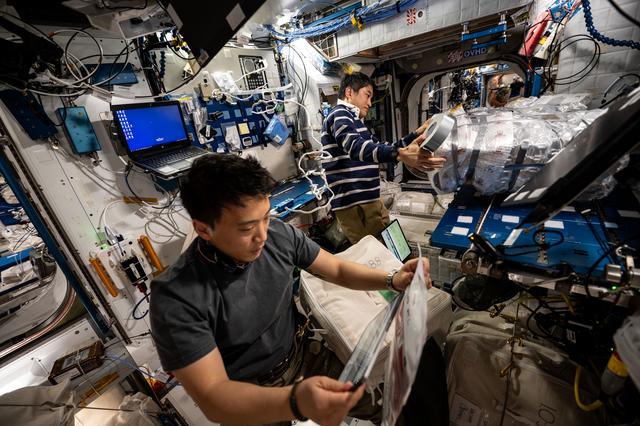 Astronauts Jonny Kim and Takuya gathers cargo to be packed inside the SpaceX Dragon cargo spacecraft