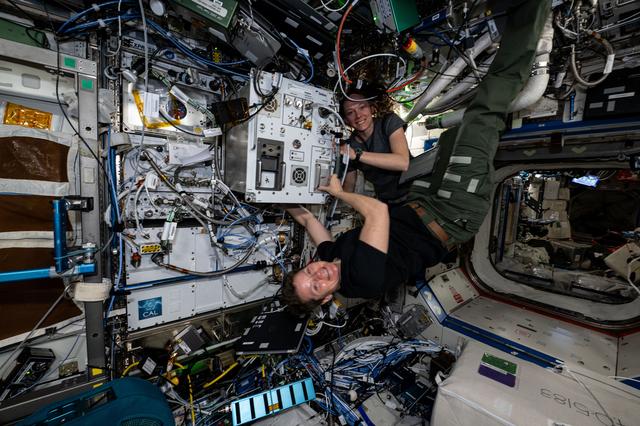 NASA image: Expedition 73 Flight Engineers Nichole Ayers and Anne McClain pose for a portrait during maintenance activities