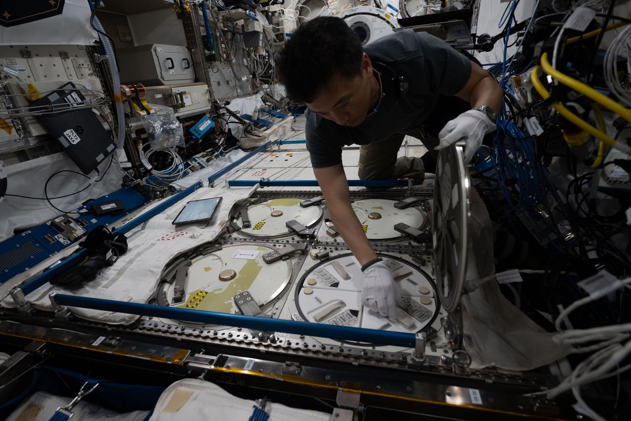 iss073e0071610 (May 16, 2025) --- NASA astronaut and Expedition 73 Flight Engineer Jonny Kim removes a cryogenic storage unit, called a dewar, containing frozen protein crystal samples from a science freezer located inside International Space Station's Kibo laboratory module. The research activities were part of a technology demonstration potentially enabling the synthesis of medications during deep space missions and improving the pharmaceutical industry on Earth.