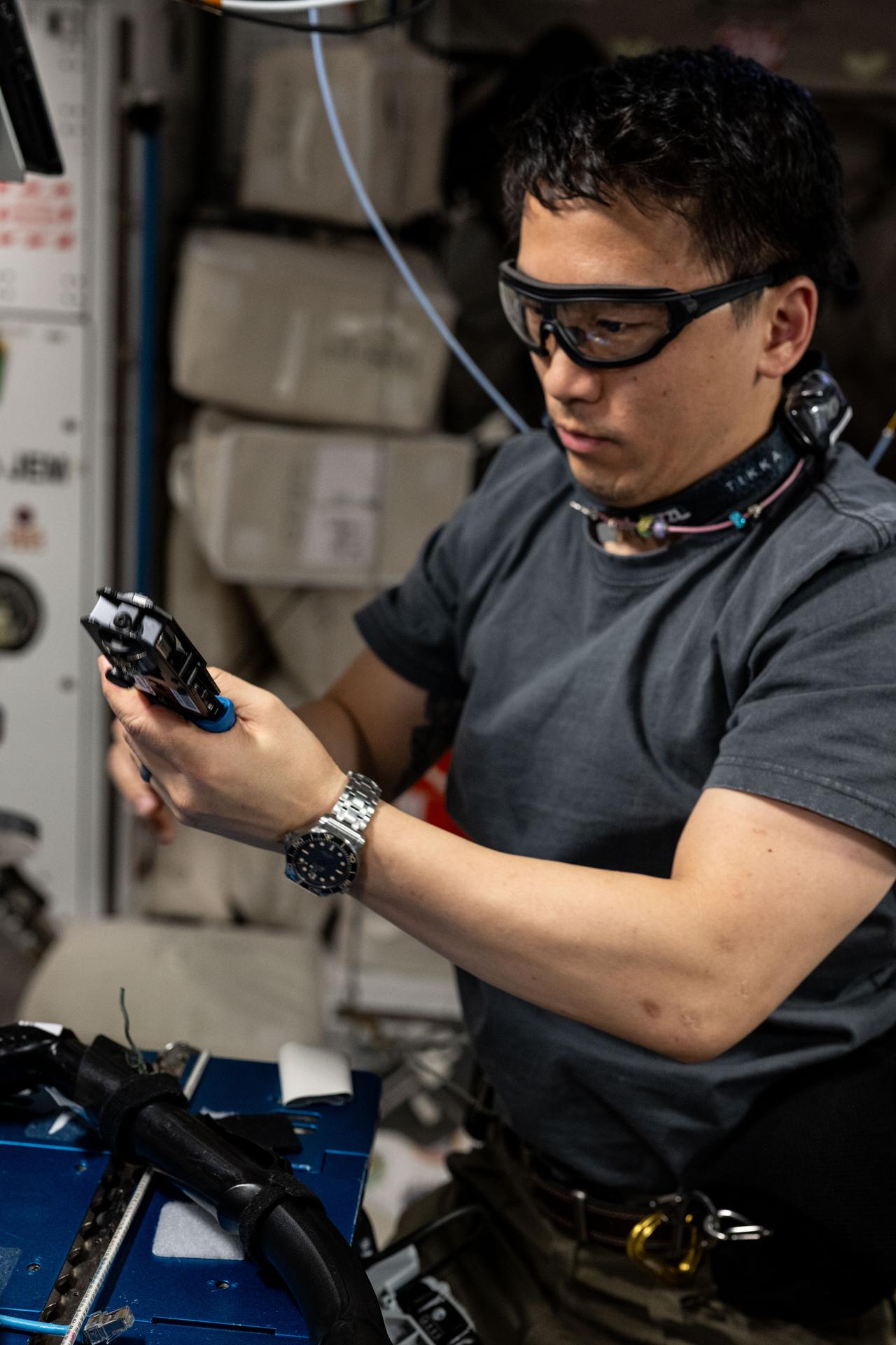 NASA astronaut and Expedition 73 Flight Engineer Jonny Kim wears goggles while working on computer network maintenance aboard the International Space Station's Harmony module.