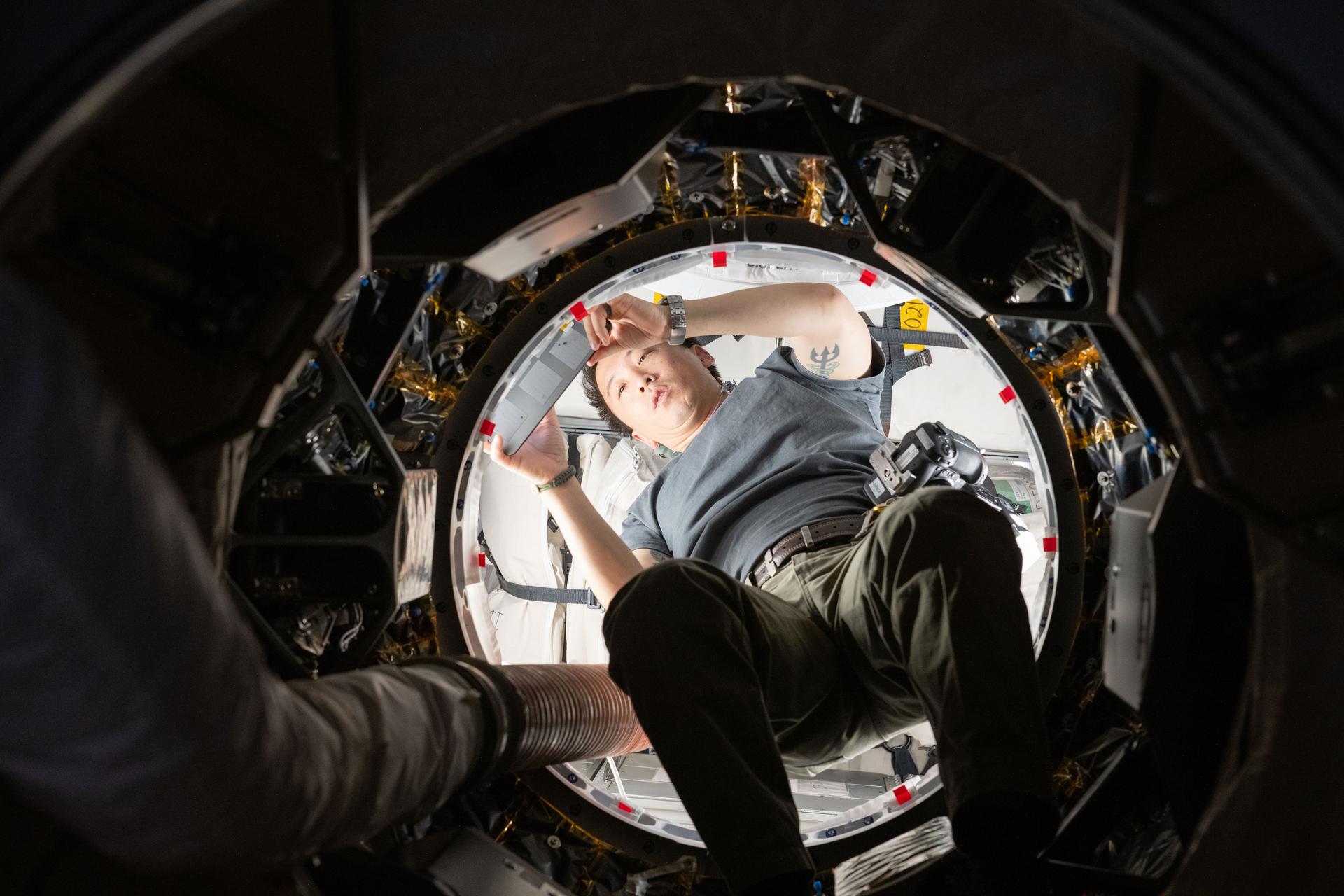 NASA astronaut and Expedition 73 Flight Engineer Jonny Kim works inside the SpaceX Dragon cargo spacecraft completing cargo operations before it undocked from the International Space Station's Harmony module several hours later.