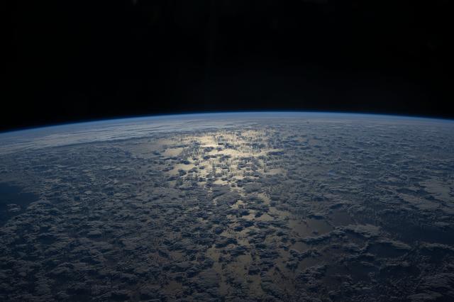 NASA image: The Sun's glint beams off a partly cloudy Indian Ocean