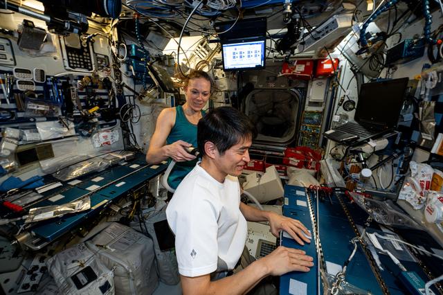 NASA image: Astronaut Nichole Ayers trims Astronaut Takuya Onishi's hair