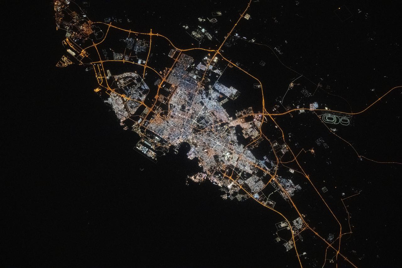 iss073e0134569 (May 22, 2025) --- Doha, the capital and largest city of Qatar with a population of about 1.9 million, is pictured at approximatelt 10:44 p.m. local time from the International Space Station as it orbited 259 miles above the Persian Gulf. Landmarks include Hamad International Airport (center left) and the artificial Pearl Island (lower center).