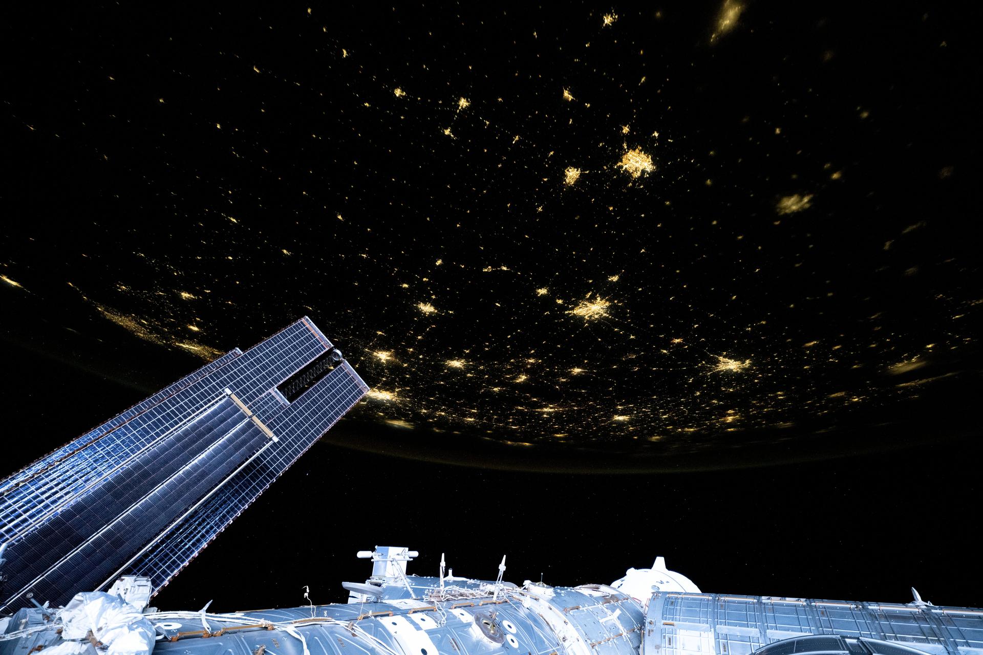 City lights dot the U.S. landscape looking southeast from 261 miles above Omaha, Nebraska, toward the southern Atlantic coast of the United States in this photograph taken at approximately 11:56 p.m. local time from the International Space Station. Pictured in the foreground, is a set of the orbital outpost's main solar arrays (lower left) and a partially obscured SpaceX Dragon crew spacecraft (lower center) docked to the Harmony module's forward port.