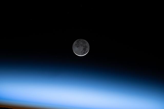 NASA image: The New Moon is pictured above Earth's atmosphere