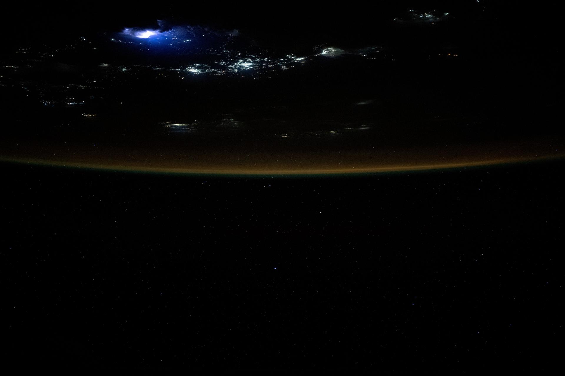 Lightning illuminates the clouds (top left) above Southeast Asia in this photograph from the International Space Station as it orbited 259 miles over the South China Sea and off the coast of the Malaysian state of Sarawak on the island of Borneo.