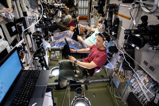 NASA image: Expedition 73 flight engineers practice an emergency drill on computer tablets
